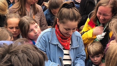Checkerin Marina verteilt Autogramme beim Kinderfest in Würzburg. | Bild: BR/Laura Pickert